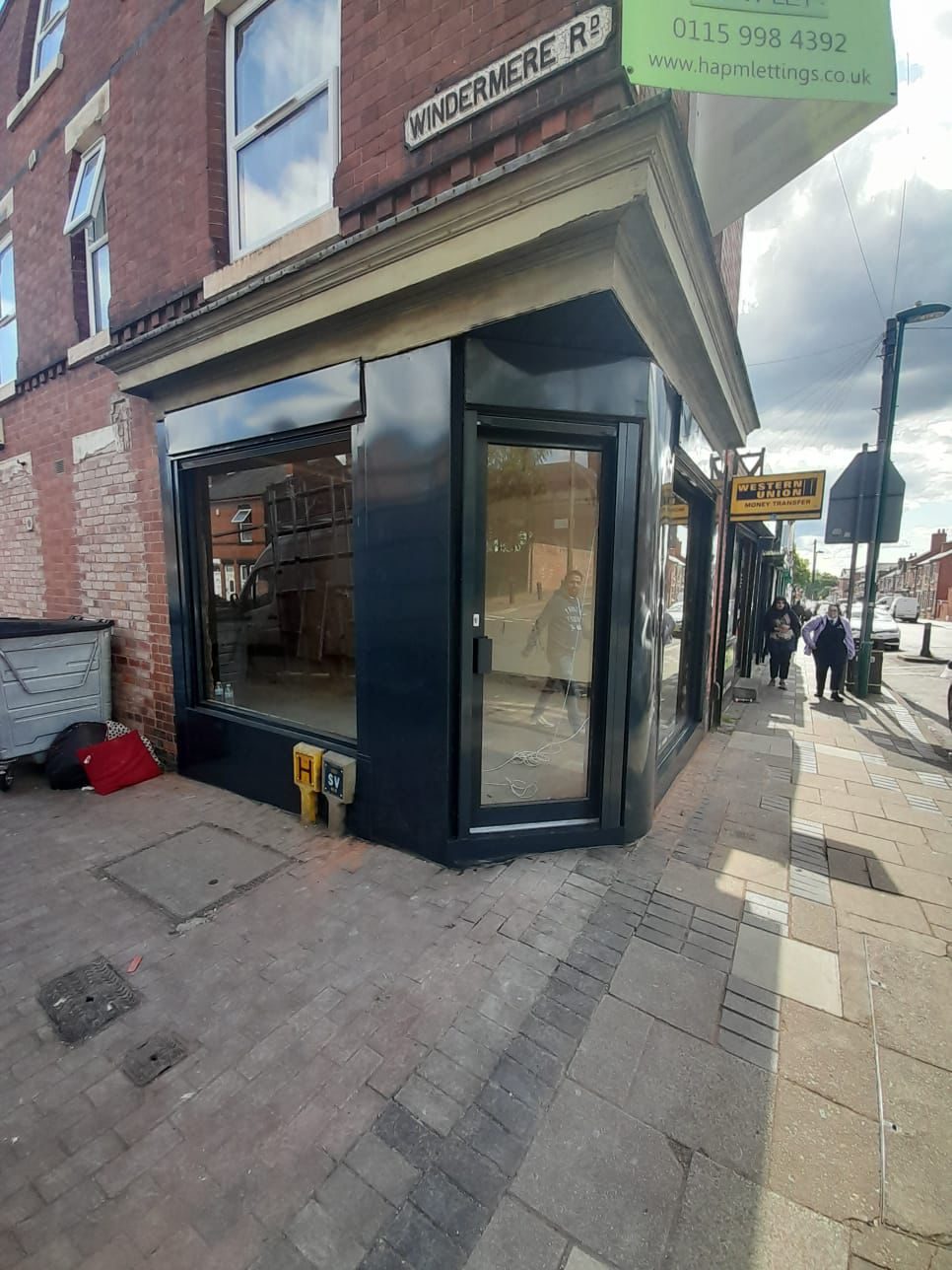 Finished black aluminium corner shopfront on a high street